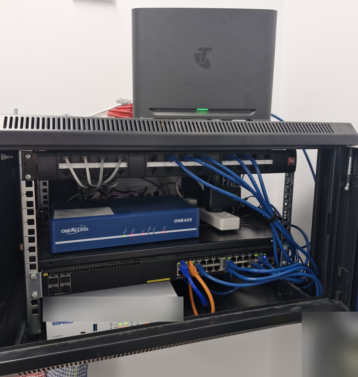Small comms rack with a Sophos firewall, tidied and labelled